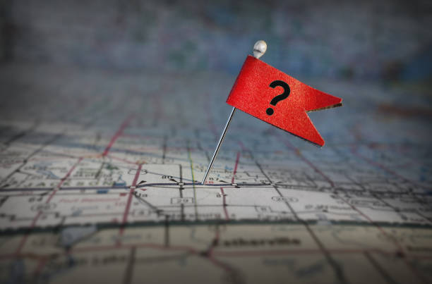 Pin with red question mark flag stuck in a map